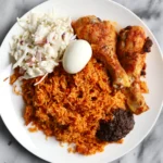 Jollof Rice with a protein, Fried Plantain, and Salad